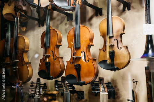 A lot of violins in a shop window selling musical instruments.