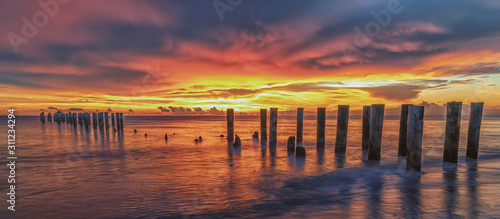 Old Pier at sunset. Scenery at the beach. Travel concept