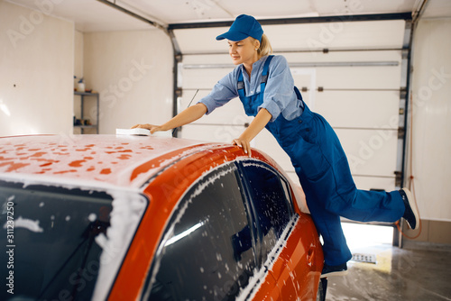 Female washer wipes the automobile windshield