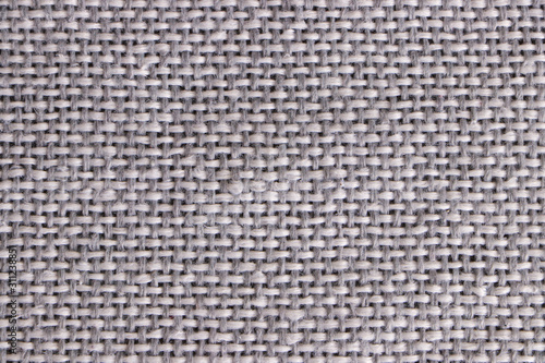 The texture of the weaves of woolen gray fabric. Closeup.