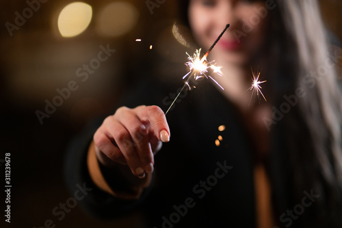 Sparkler close-up in the hands of a girl. burning sparkling fireworks.