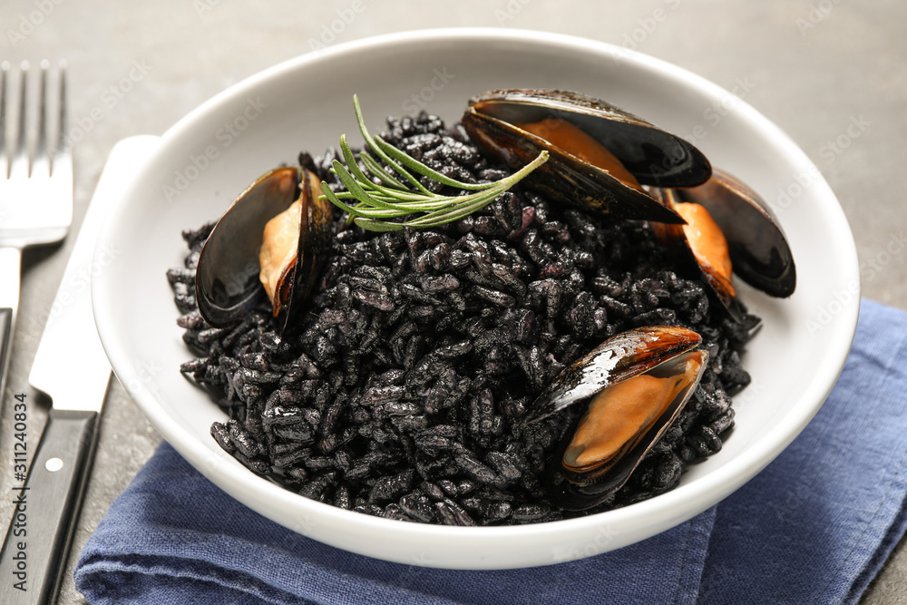 Delicious black risotto with seafood in bowl on table, closeup Delicious black risotto with seafood in bowl on table, closeup