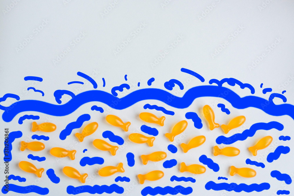Omega vitamins for children in the form of fish on a blue background. Useful supplements for children. Omega vitamins for children in the form of fish on a blue background. Useful supplements for children.