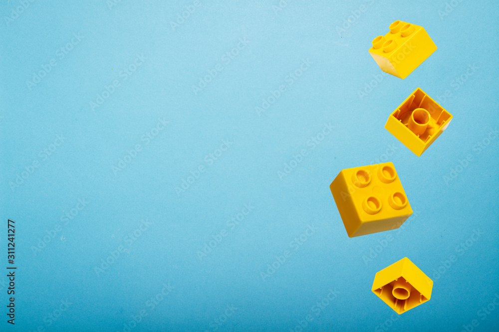 Details of a toy constructor fly in the air against a blue background. Levitation. Logic concept, kids toys. Flat lay, top view Details of a toy constructor fly in the air against a blue background. Levitation. Logic concept, kids toys. Flat lay, top view