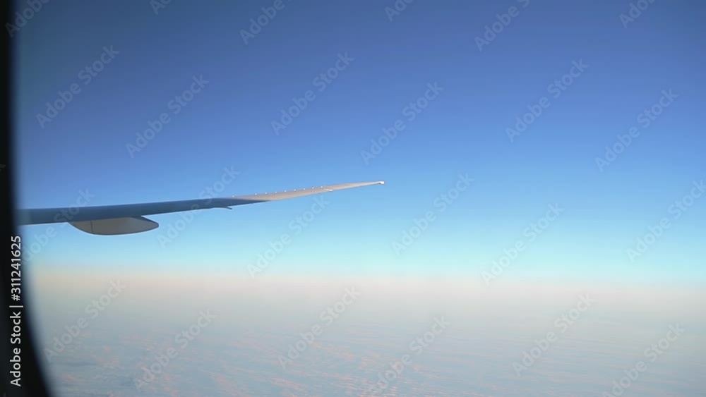 Window seat is the best seat in plane to relax during air travel. Passenger pov through plane window flight during sunset or sunrise above clouds. Close up of porthole of flying airplane at night. Window seat is the best seat in plane to relax during air travel. Passenger pov through plane window flight during sunset or sunrise above clouds. Close up of porthole of flying airplane at night.