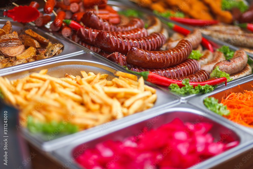 Fototapeta premium Various food at the annual christmas fair. Fried sausages, french fries and other tasty food