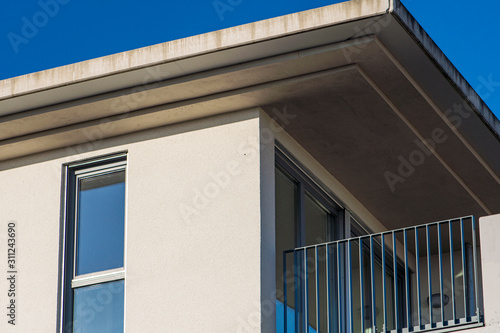 Φωτογραφία House facade with balcony and roof overhang