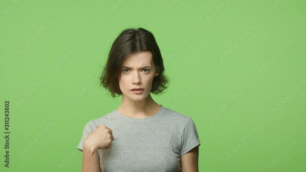 Slow-motion woman shocked and concerned, say what surprised, pointing herself, being accused, deny accusations, shaking head in negative reply, standing offended over green background Slow-motion woman shocked and concerned, say what surprised, pointing herself, being accused, deny accusations, shaking head in negative reply, standing offended over green background