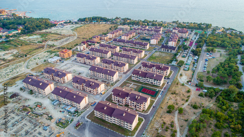 Residential complex of more than twenty five-storey houses on the beach at sunset