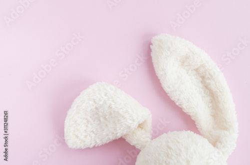 Easter flat lay with bunny rabbit white ears on pink background, top view, copy space. 