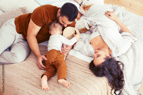 young happy family together having fun in bed, lifestyle people concept