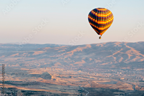 Aerial view of hot air balloons flying over Turkish mountain landscape in the Goreme National Park, Cappadocia