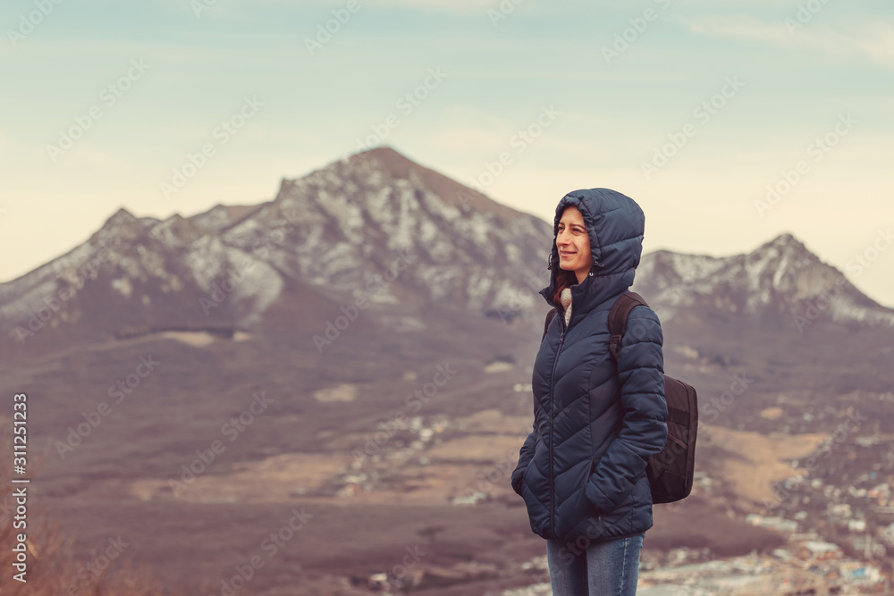 young woman with backpack on mountain top on mountain background