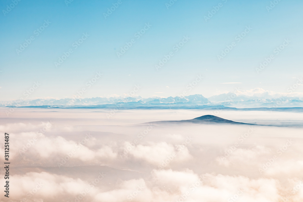 aerial view on a mountains covered clouds from the plane