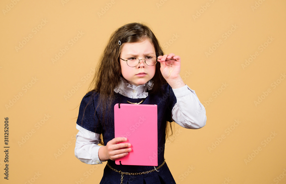 serious small girl wants to be teacher. notebook for diary notes. study lesson. knowledge and education. Back to school. hometwork. small girl with paper folder. School curriculum