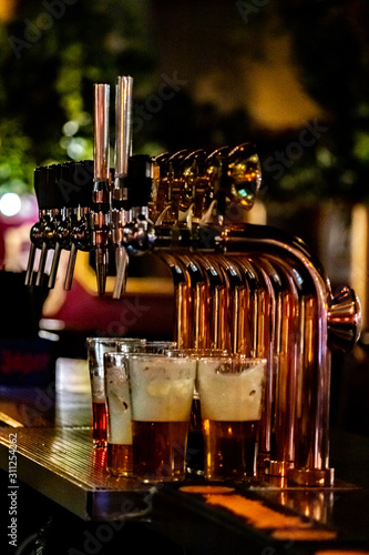 Beer taps in the bar with dialed beer glasses. Beer.