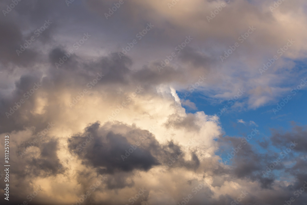 Beautiful epic storm grey cumulus clouds against blue sky background texture