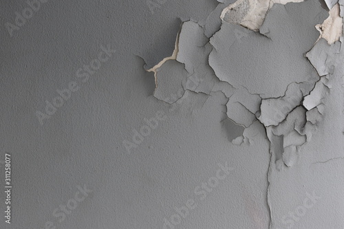 Background texture of old cement wall with gray paint peeling off.