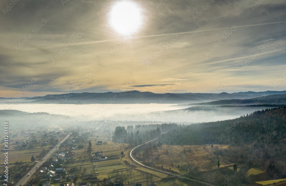 Fog in mountains before sunrise, mountain valley with clouds. View to mountains of the Carpathians Fog in mountains before sunrise, mountain valley with clouds. View to mountains of the Carpathians