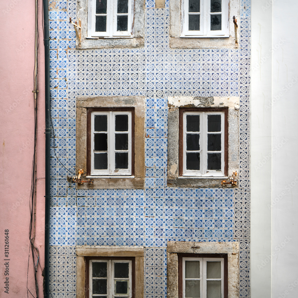 the typical decorative tiles on the wall of an old house in the neighborhood of Alfama in Lisbon, Portugal