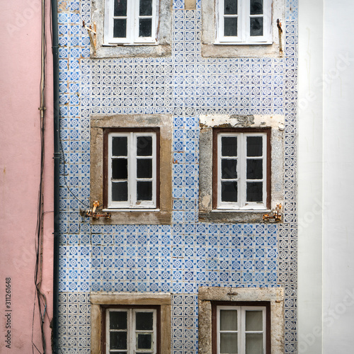 the typical decorative tiles on the wall of an old house in the neighborhood of Alfama in Lisbon, Portugal