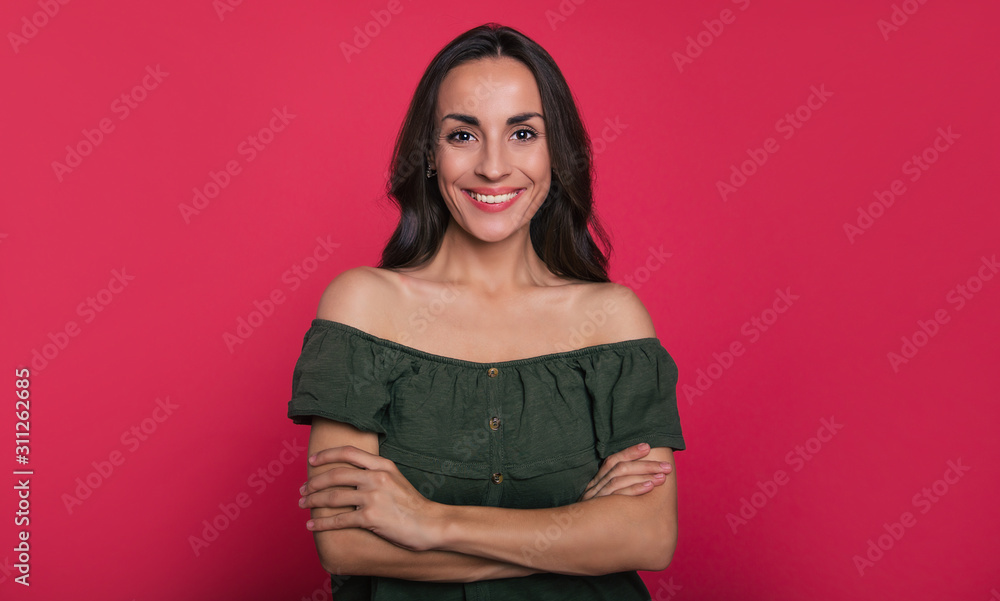 High hopes. Close-up photo of a lovely young woman with long dark hair, who is posing in a green dress with cutaway shoulders and looking in the camera with her hands folded. High hopes. Close-up photo of a lovely young woman with long dark hair, who is posing in a green dress with cutaway shoulders and looking in the camera with her hands folded.
