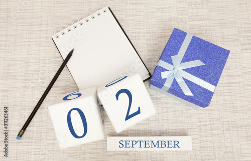 Gift box and wooden calendar with trendy blue numbers, September 2, business planner