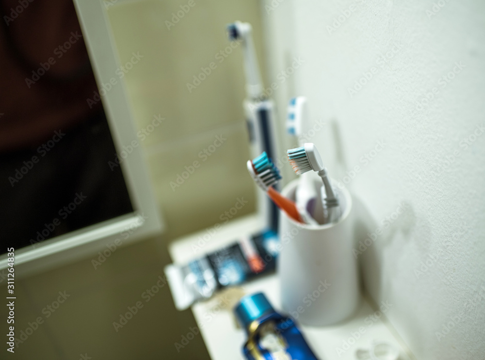 Elevated view of bathroom shelf with multiple toothbrush