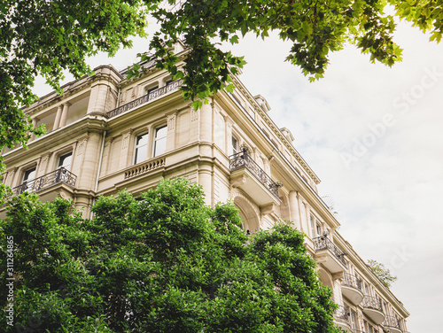 Photography View through green trees of dream parisian apartment building real estate in Fra