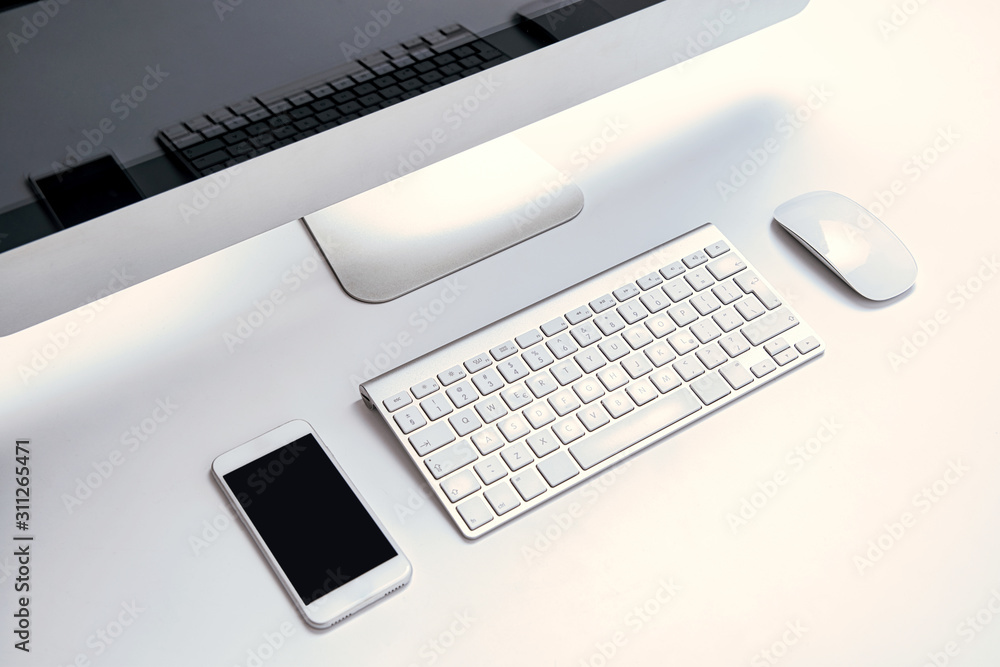 Office work place, computer, keyboard, mouse and telephone with blank display. The concept of office work, computer equipment. Modern and bright office with computer equipment. Communication at work. Office work place, computer, keyboard, mouse and telephone with blank display. The concept of office work, computer equipment. Modern and bright office with computer equipment. Communication at work.