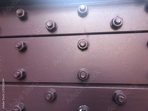 abstract metal background with rivets and screws © Samantha