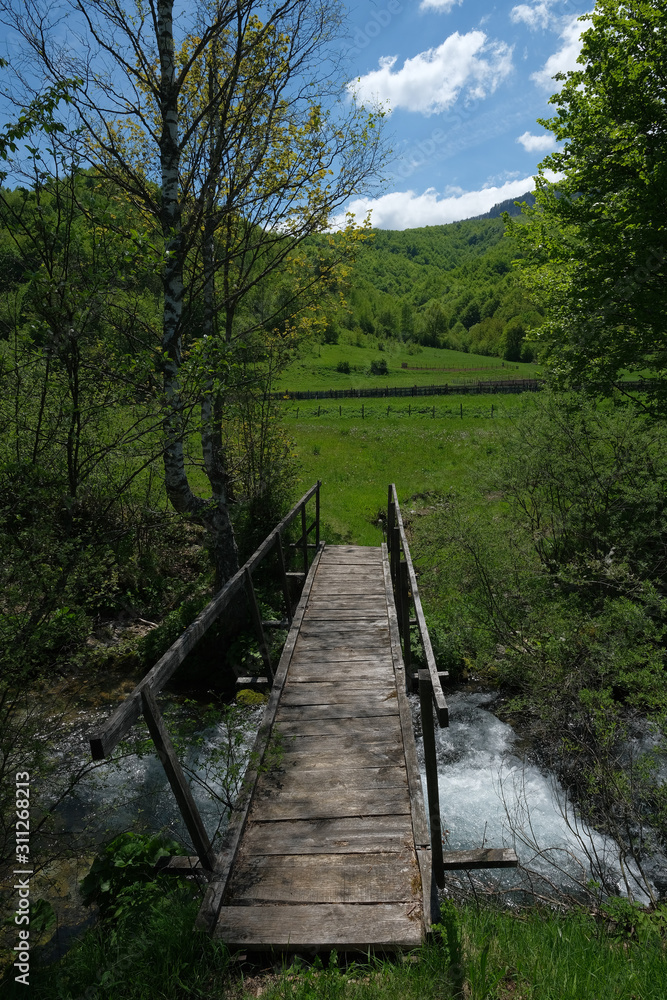 Wooden bridge over a mountain stream.