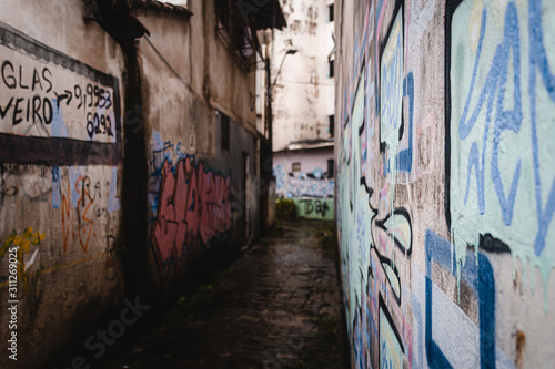 Callejon mojado en dia de lluvia con grafitis en las paredes © Bruno