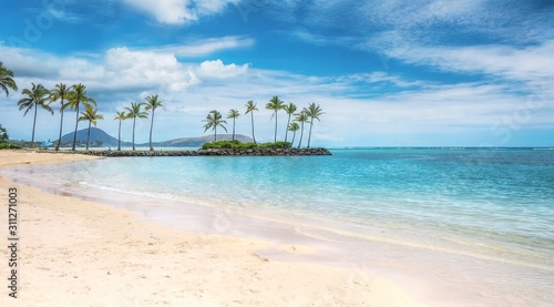 Fototapeta Naklejka Na Ścianę i Meble -  A beautiful beach scene in the Kahala area of Honolulu, with fine white sand, shallow turquoise water, a view of coconut palm trees and Diamond Head in the background.