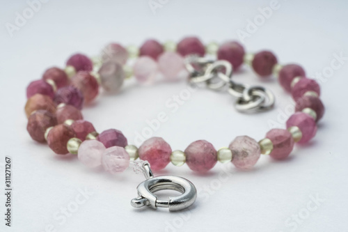 Handmade bracelet made of pink tourmaline, green chalcedony on a white background