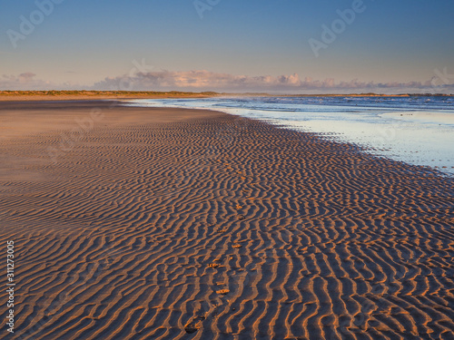 a gloriously wide sandy beach that seems to stretch for miles into the distance and the site of the majestic ruins of Dunstanburgh Castle. photo