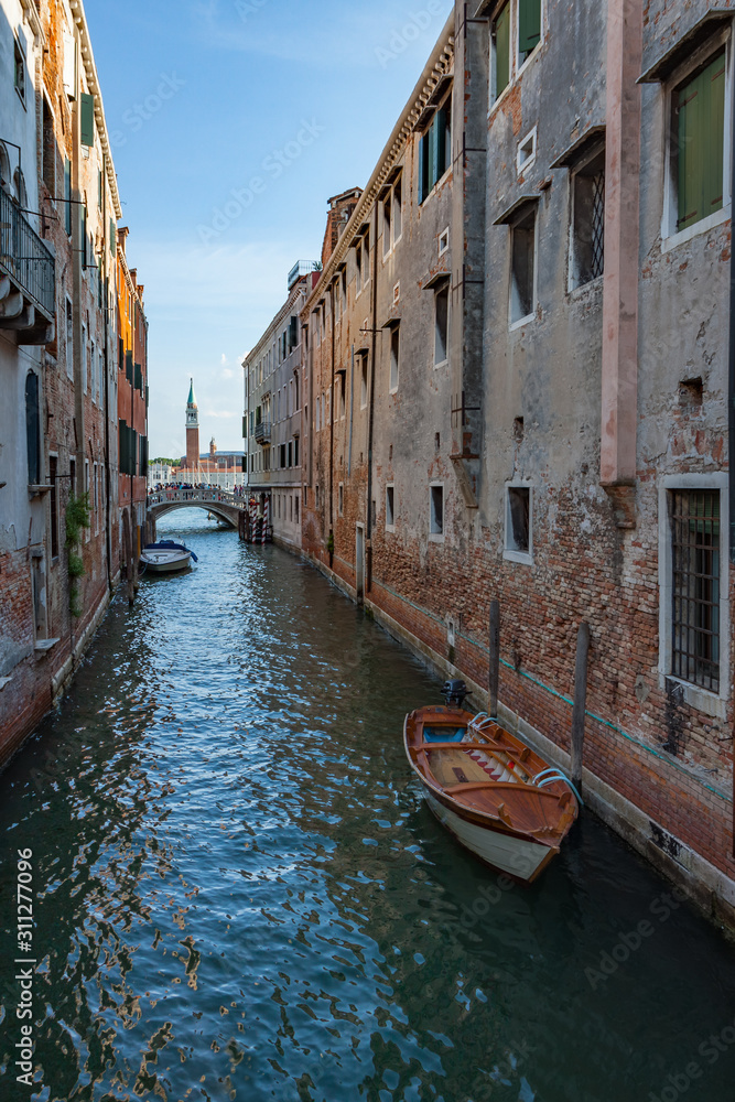 Boat in Narrow Canal in Venice with Campanile in Background