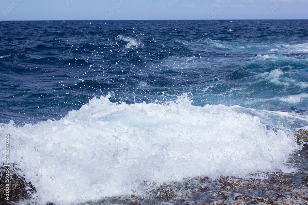 Obraz premium Blue atlantic ocean, white foam and volcanic rock