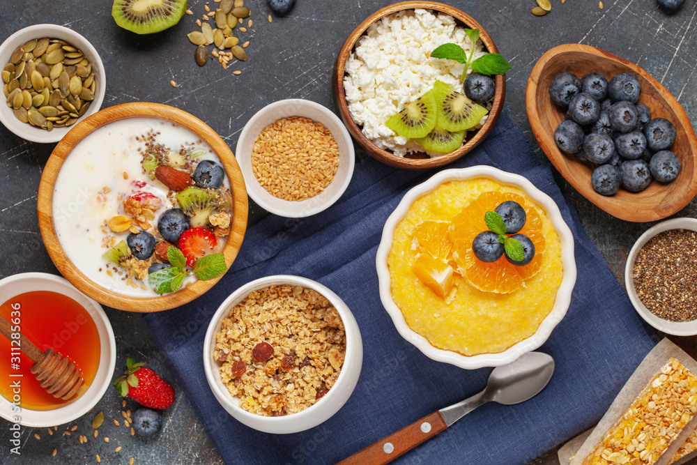 Healthy breakfast set with corn porridge, yogurt, berries, coffee and granola. Top view. Flat lay