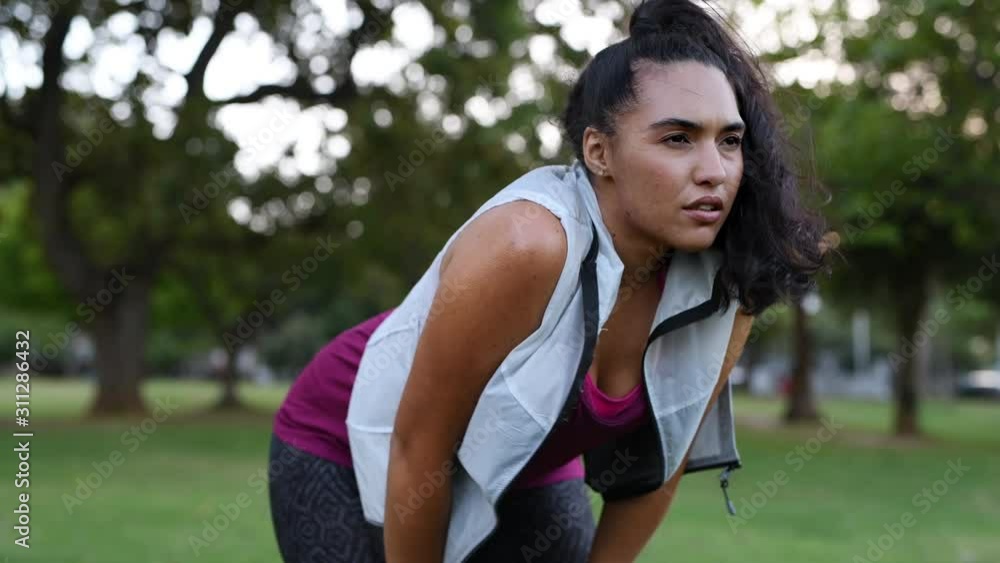 Tired young woman resting after jogging outdoor. Determined latin girl sweating and taking a rest after running hard. Exhausted curvy woman in sportswear doing breathing exercise. Tired young woman resting after jogging outdoor. Determined latin girl sweating and taking a rest after running hard. Exhausted curvy woman in sportswear doing breathing exercise.