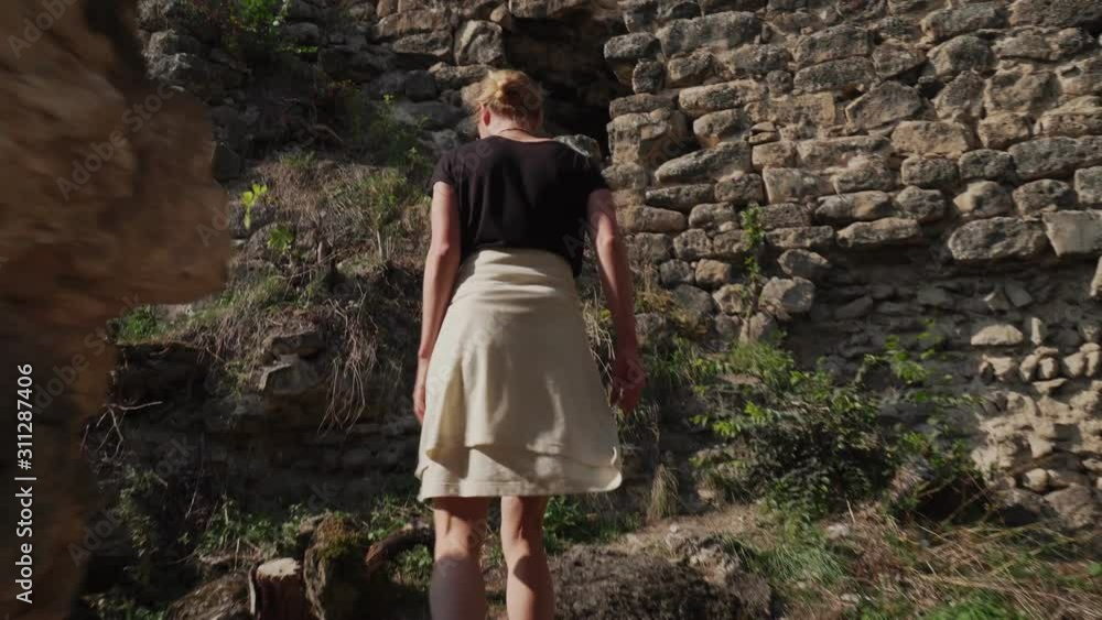 Attractive tourist blonde female walk in old medieval castle Attractive tourist blonde female walk in old medieval castle