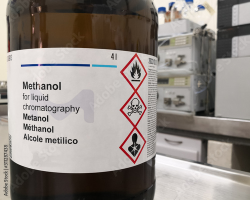 Fotografia Amber glass bottle for lightning protection containing methanol, an HPLC grade alcohol, and a label with GHS warnings about toxicity, flammability and death