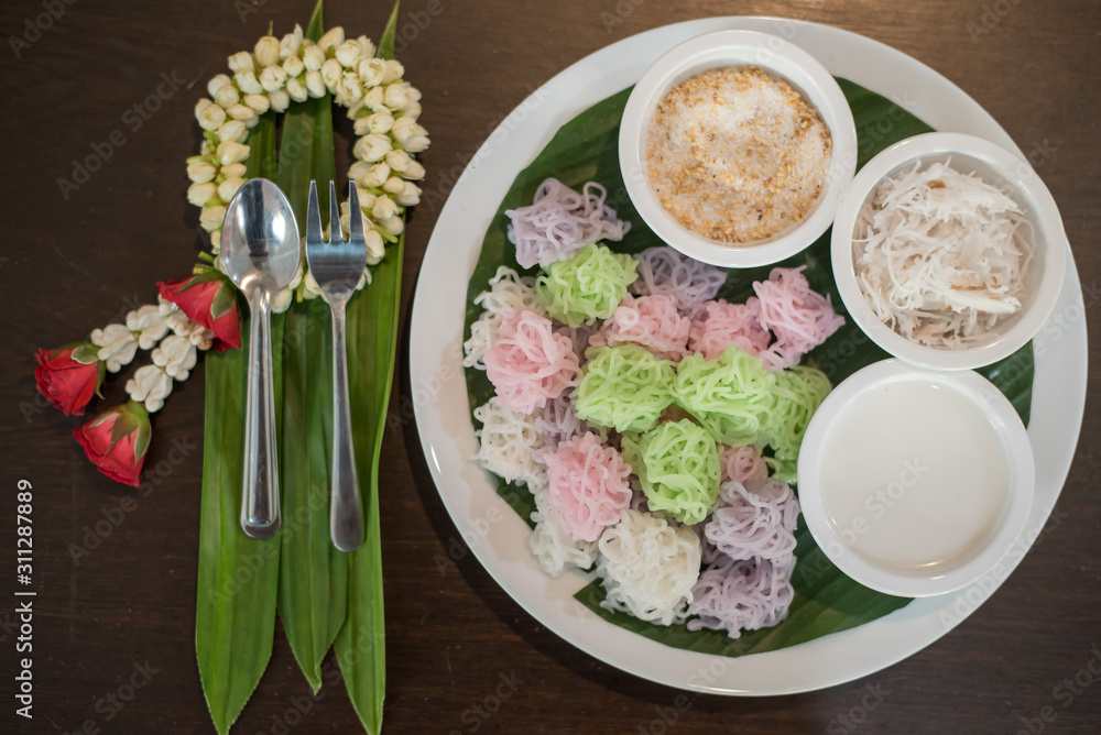 Colorful Thai Desserts (Ka-Nhom-Ray-Rai or Rang-rai ) Rice flour dumpling topped coconut milk and sugar mixed with sesame (Thailand traditional food)