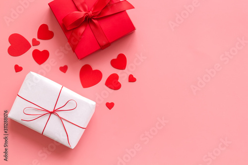 Present to a lover on Valentine's Day. Gift boxes near paper hearts on pink background top-down frame copy space © 9dreamstudio