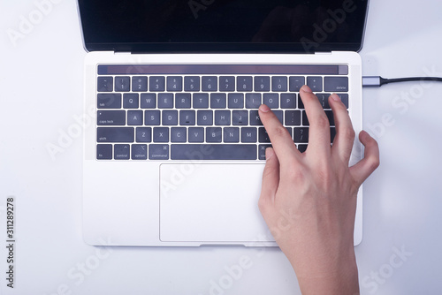 Woman hand pressing keyboard shortcut on laptop keyboard photo