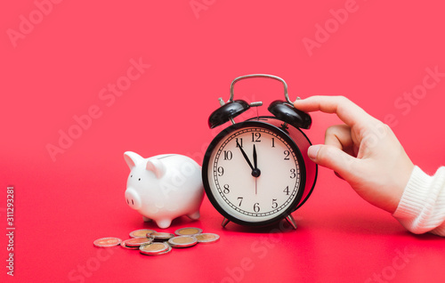 woman hand putting money coin into piggy