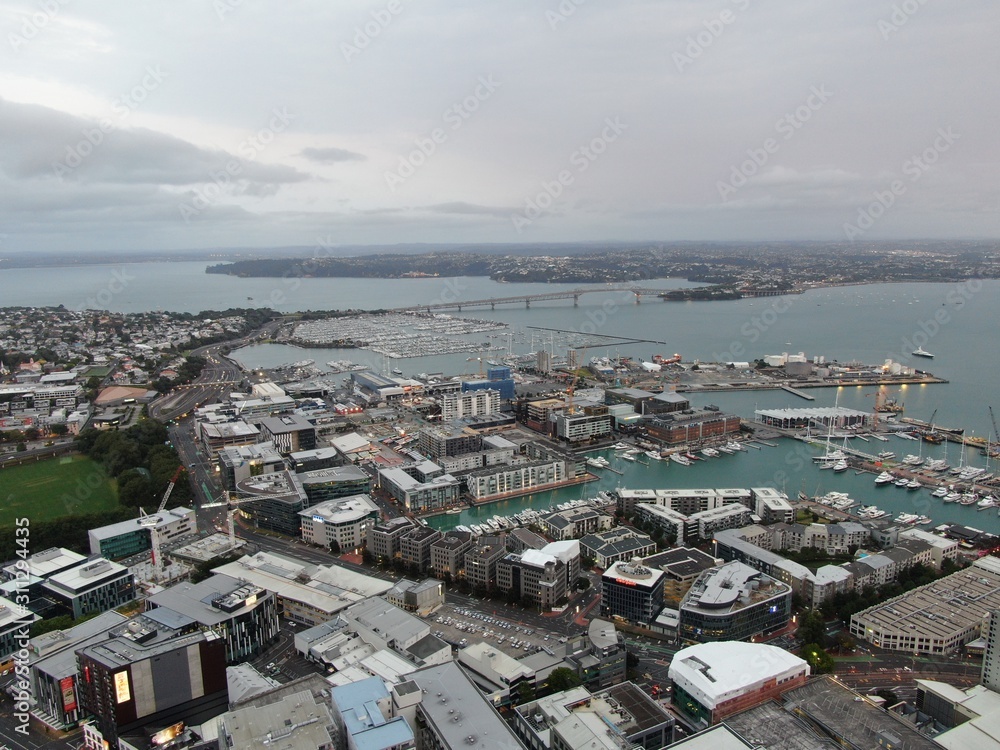 Viaduct Harbour, Auckland / New Zealand - December 23, 2019: The iconic Skytower landmark of Auckland City and its surrounding buildings