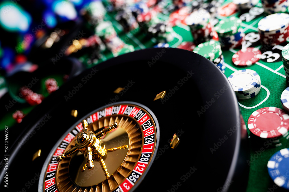 Casino theme, close up of roulette, red and black numbers, Stack of chips as background. Casino theme, close up of roulette, red and black numbers, Stack of chips as background.