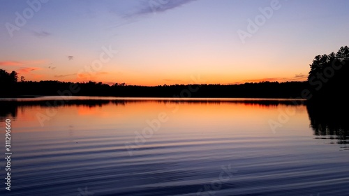 sunset over lake with tree line