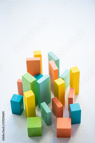 Blue, orange, yellow and green flat wooden bricks and cubes making up chart